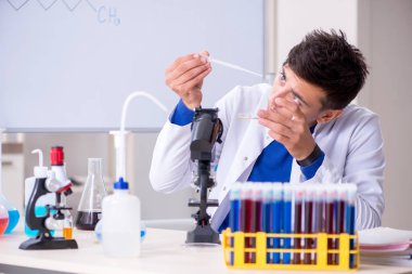 Laboratuarda oturan genç kimyager 