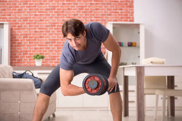 Joven hombre guapo haciendo ejercicios deportivos en casa —  Fotos de Stock