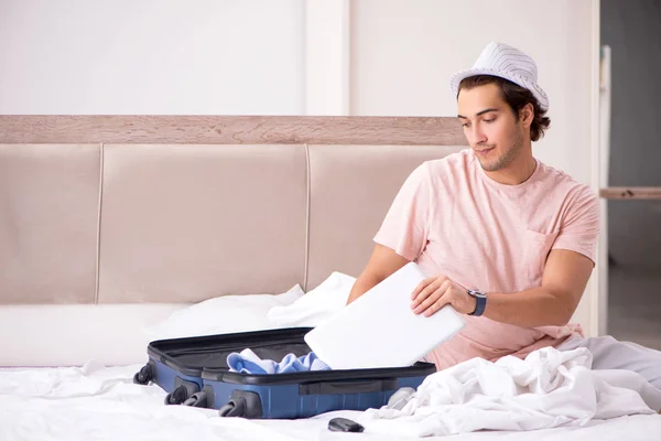 Człowiek z walizka w sypialni, czekając na podróż — Zdjęcie stockowe