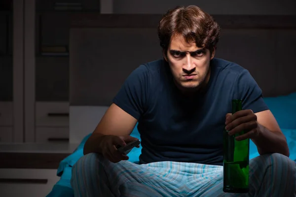 Man drinking in the bed under stress — Stock Photo, Image