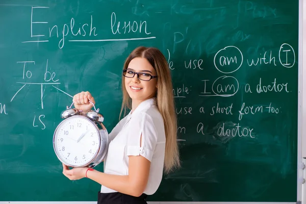 Unga kvinnliga engelska lärare står framför b — Stockfoto