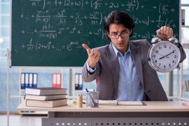 Genç yakışıklı matematik öğretmeni sınıfta 