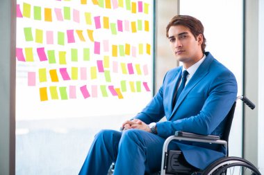 Birçok çelişkili önceliği olan tekerlekli sandalyedeki genç yakışıklı adam.