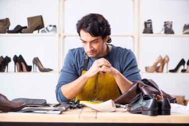 Genç adam ayakkabı atölyesinde tamir 