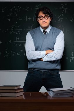 Kara tahta önünde genç matematik öğretmeni