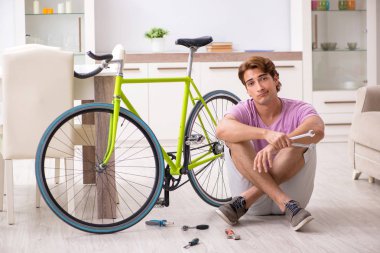Kırık bisikletini tamir eden adam.