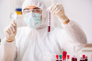 Genç yakışıklı laboratuvar asistanı hastanede kan örnekleri test ediyor. 