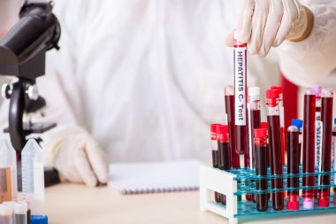Genç yakışıklı laboratuvar asistanı hastanede kan örnekleri test ediyor. 
