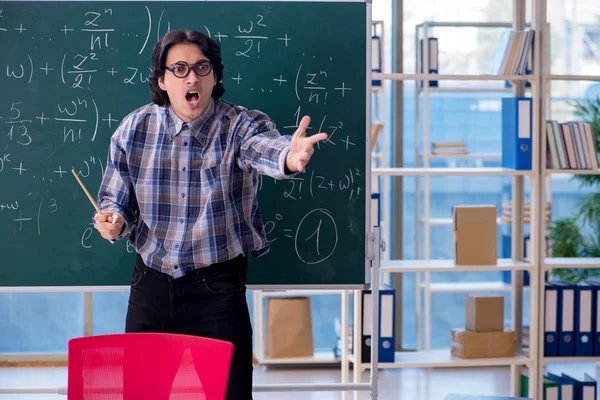 Jovem professor de matemática engraçado na frente do quadro — Fotografia de Stock