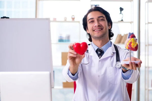 Jovem cardiologista médico bonito na frente do quadro branco — Fotografia de Stock