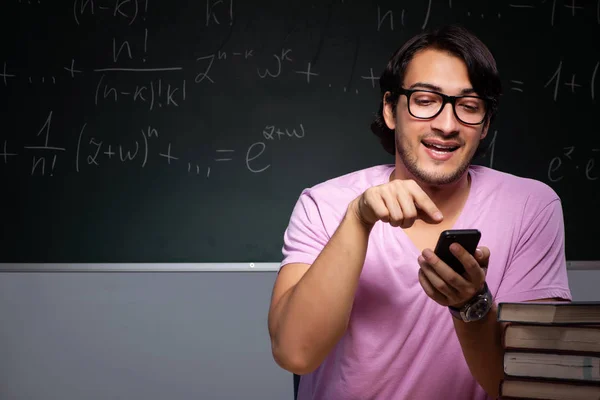 Young male student sitting in classroom — Stock Photo, Image