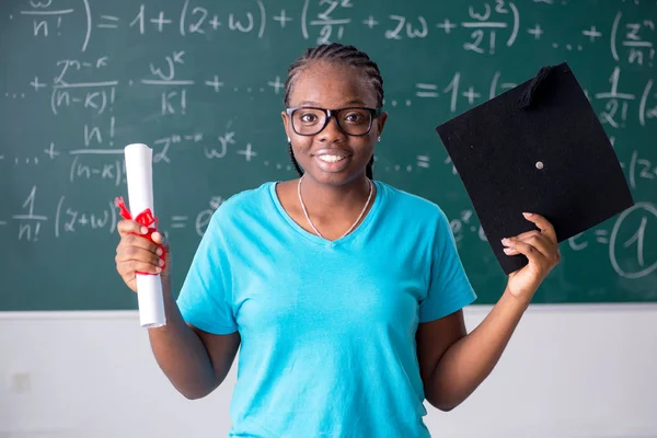 Black female student in front of chalkboard — Stock Photo, Image