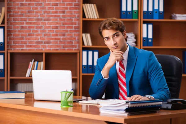 Jovem e bonito empregado sentado no escritório — Fotografia de Stock