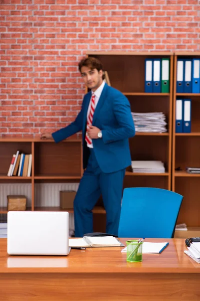 Joven empleado guapo sentado en la oficina — Foto de Stock