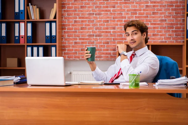 Fiatal jóképű alkalmazott ül az irodában — Stock Fotó