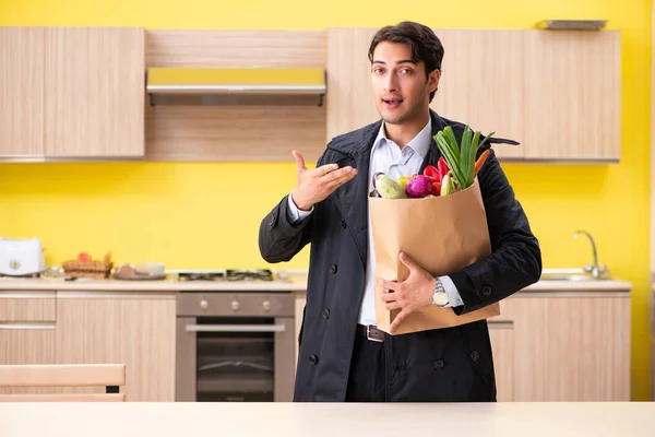 Joven hombre guapo con verduras en la cocina — Foto de Stock