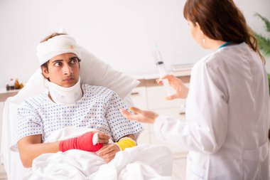 Genç doktor yaralı hastayı muayene ediyor. 