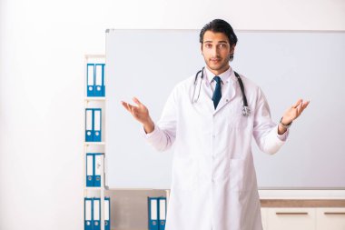 Genç doktor beyaz tahtanın önünde.