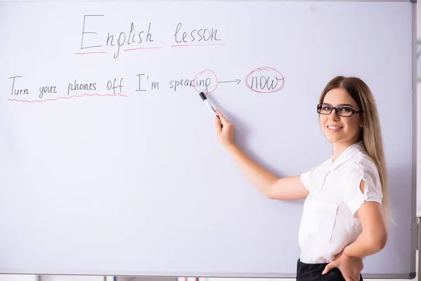 Jonge vrouwelijke Engels leraar staande voor de b — Stockfoto