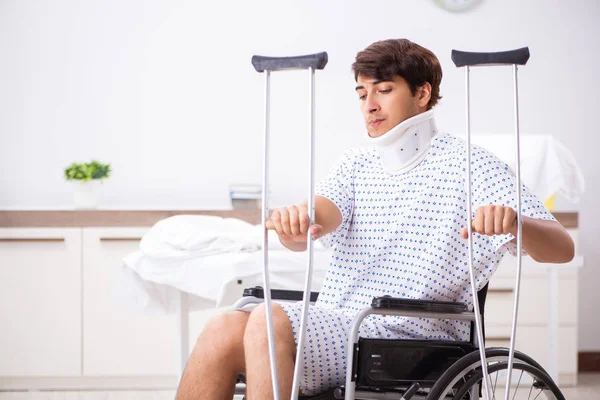 Mladý pohledný muž na vozíku v nemocnici — Stock fotografie
