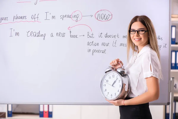 Jonge vrouwelijke Engels leraar staande voor de b — Stockfoto