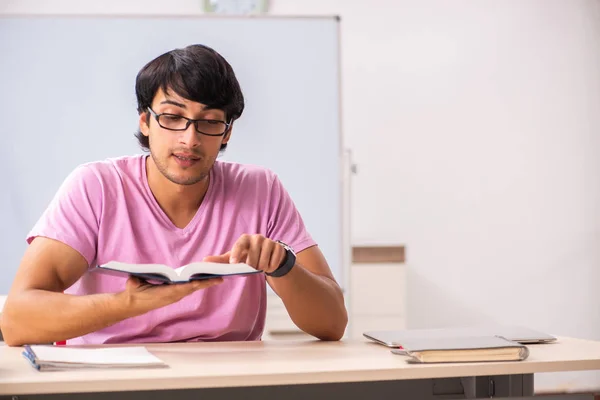 Mladý muž student sedí ve třídě — Stock fotografie