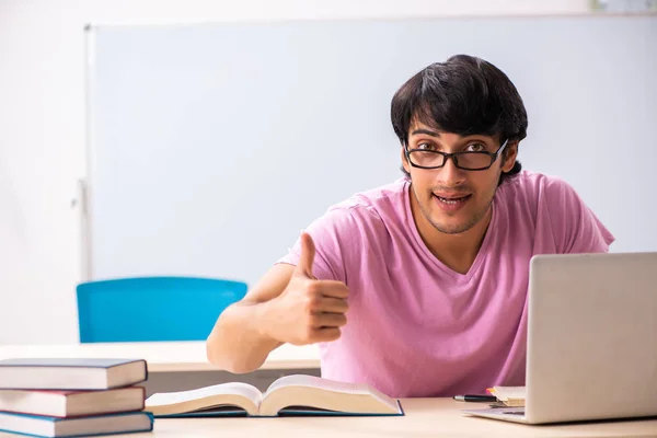 Jovem estudante do sexo masculino sentado na classe — Fotografia de Stock