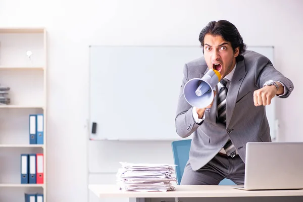 Young employee boss with megaphone in the office — Stock Photo, Image