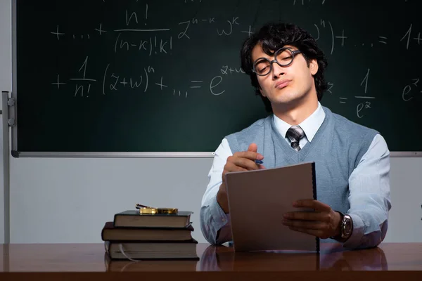 Jovem professor de matemática na frente do quadro — Fotografia de Stock