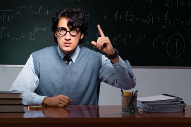 Kara tahta önünde genç matematik öğretmeni