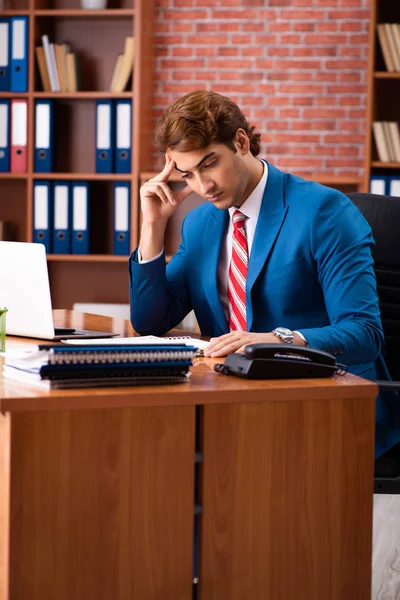 Genç yakışıklı çalışan ofiste oturuyor. — Stok fotoğraf