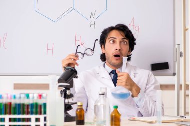 Beyaz tahta önünde genç komik kimyager
