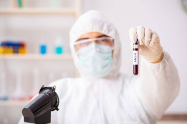 Genç yakışıklı laboratuvar asistanı hastanede kan örnekleri test ediyor.