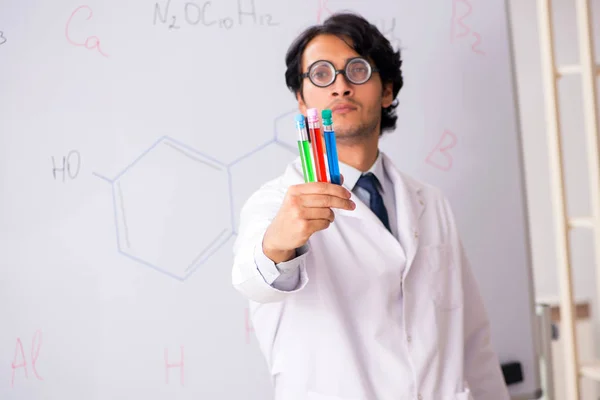 Young funny chemist in front of white board — Stock Photo, Image