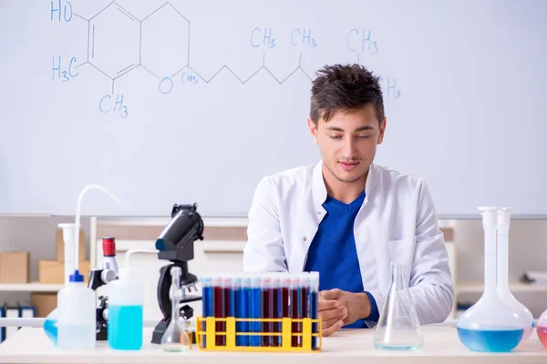 Молодой химик сидит в лаборатории — стоковое фото