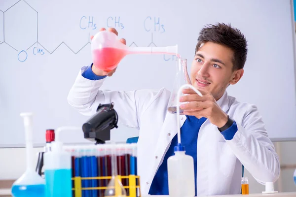 Junge Chemikerin sitzt im Labor — Stockfoto