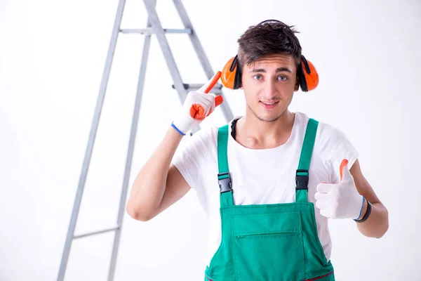 Young worker with earmuffs in noise cancelling concept — Stock Photo, Image