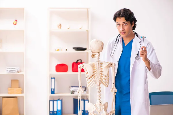Young male doctor with skeleton — Stock Photo, Image