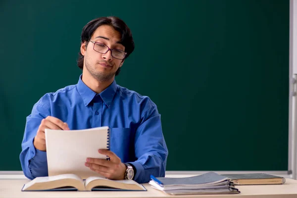 Jeune professeur masculin devant un tableau noir — Photo