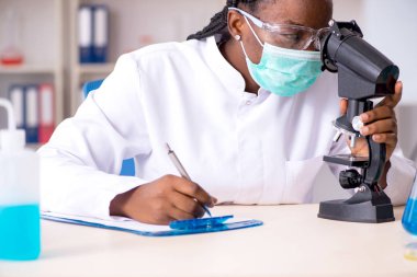 Laboratuarda çalışan genç siyah kimyager