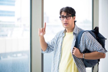 Genç yakışıklı öğrenci pencerede duruyor.