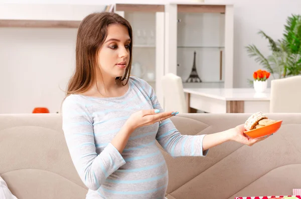 Jonge zwangere vrouw zittend op de Bank thuis — Stockfoto