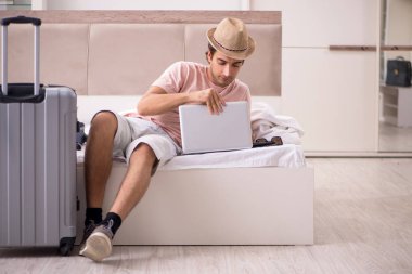 Bavul seyahat için bekleyen yatak odasında olan adam