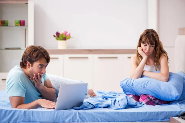Junges Paar mit Laptop im Schlafzimmer — Stockfoto