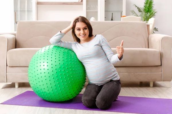 Молода вагітна жінка робить спортивні вправи вдома — стокове фото