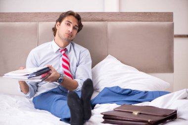 Evde yatakta oturup genç çalışan