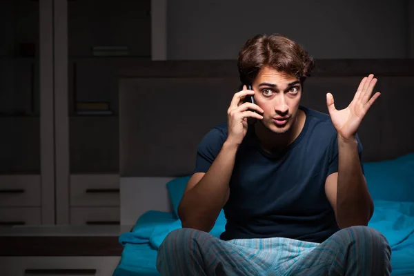A fiatalember beszél a mobil késő este — Stock Fotó