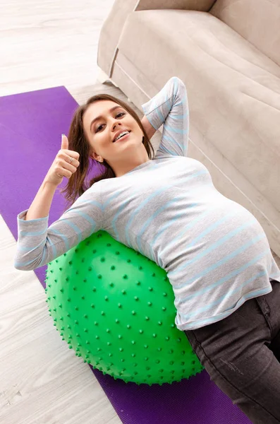 Νεαρή έγκυος γυναίκα, κάνει αθλητισμό ασκήσεις στο σπίτι — Φωτογραφία Αρχείου