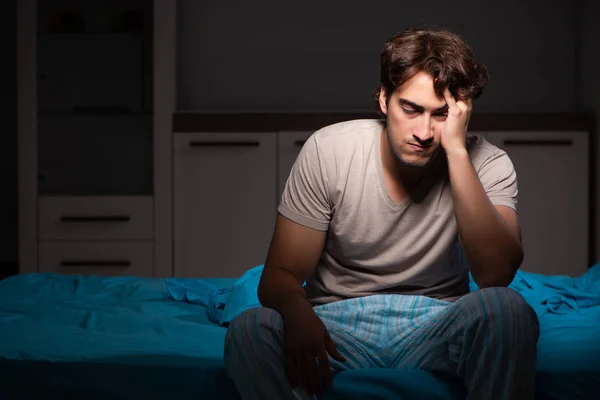 Fiatal jóképű férfi szenvednek álmatlanságban az ágyban — Stock Fotó