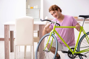 Kırık bisikletini tamir eden adam.